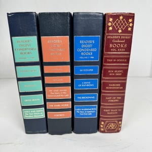 Könnte beinhalten: Vier Vintage Reader's Digest Condensed Books. Die Bücher haben dunkelblaue und weinrote Buchrücken mit farbigen Etiketten. Zu den Titeln gehören "Grass Roots", "Skyscraper" und "First Train to Babylon".