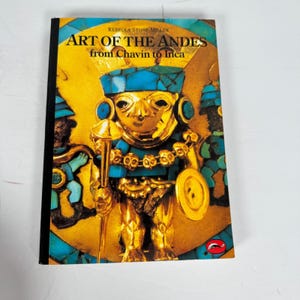 May include: A hardcover book titled "Art of the Andes from Chavin to Inca" by Rebecca Stone-Miller. The cover features a gold-colored figure with turquoise accents, holding a staff and shield, set against a gold and turquoise background.
