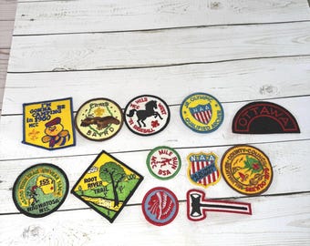 Lot med 13 vintage scoutmärken, MCC, BSA, 1980-talets Milwaukee bågskyttevandringscamping