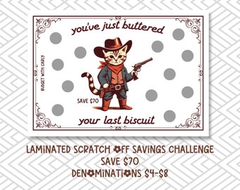 May include: A white card with a cartoon cat wearing a cowboy hat and holding a gun. The card has a red border and says "you've just buttered your last biscuit". It also says "Save $70" and "Laminated Scratch Off Savings Challenge".