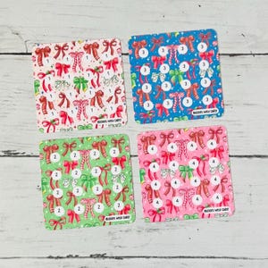 May include: Four square savings challenge cards featuring repeating bow patterns in white, blue, green, and pink. Each card displays circular icons with the numbers 1, 2, 3, or 4, and the text Budget with Carly printed in the bottom right corner.