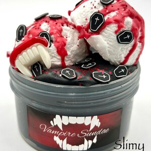 May include: A black slime jar with a red and black label that says "Vampire Sundae". The slime is topped with white and red ice cream with black coffin sprinkles.