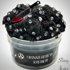 May include: Black slime with white ghost face charms and a red-handled knife charm in a clear plastic container. The label reads "I wanna hear ya scream!!!" and "Slimy Jester".