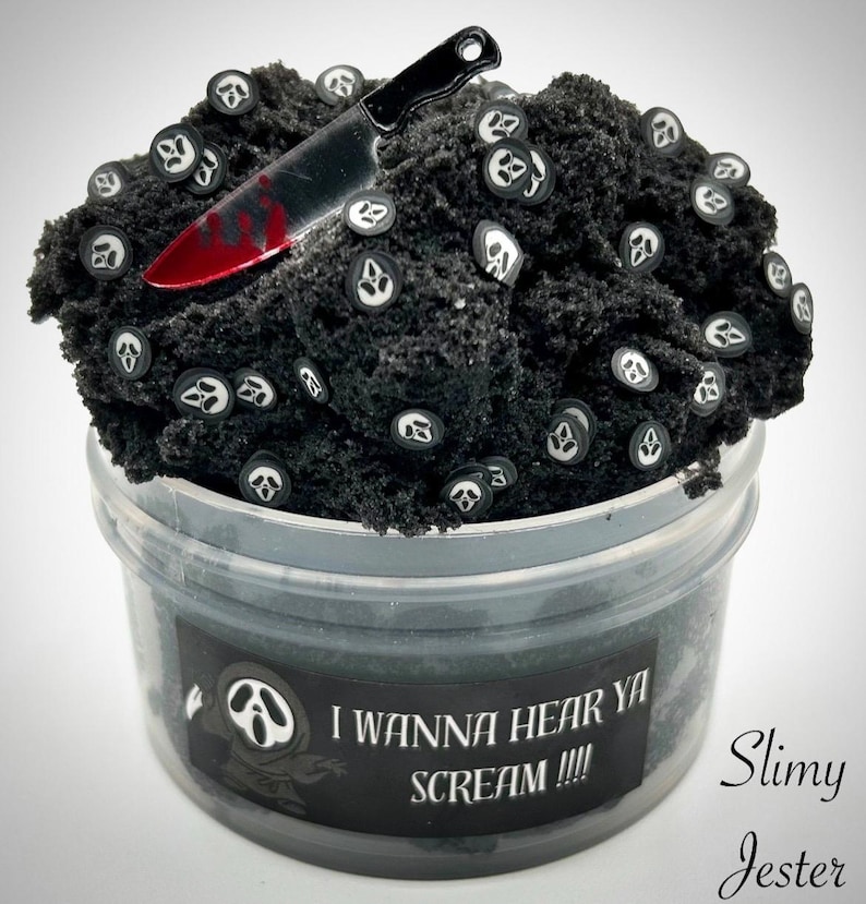 May include: Black slime with white ghost face charms and a red-handled knife charm in a clear plastic container. The label reads "I wanna hear ya scream!!!" and "Slimy Jester".