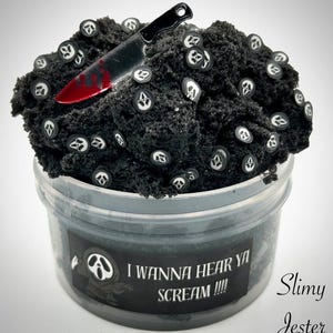 May include: Black slime with white ghost face charms and a red-handled knife charm in a clear plastic container. The label reads "I wanna hear ya scream!!!" and "Slimy Jester".