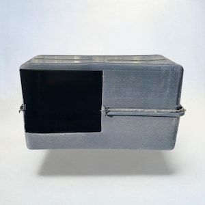 May include: A gray, rectangular pet carrier with a large opening on one side. The carrier is made of a durable plastic material and features a textured surface. The carrier is designed for small animals.