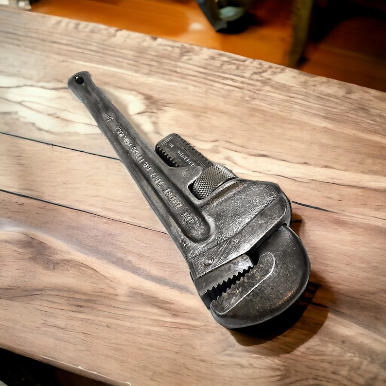 Puede incluir: Una llave de tubo vintage de color plateado con el texto "THE RIDGE TOOL CO.  ELYRIA, OHIO" en el mango.