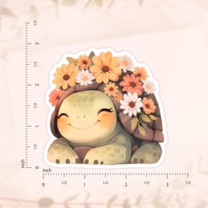 May include: A smiling cartoon turtle wearing a crown of orange, pink, and white flowers. The turtle is sitting on a white background.