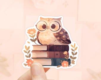 Puede incluir: Un búho marrón y blanco con gafas se sienta encima de una pila de tres libros. Los libros están decorados con detalles florales y el búho está rodeado de pequeñas flores.