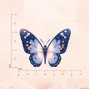 May include: A blue butterfly sticker with white and orange floral accents. The sticker is approximately 5 cm wide.