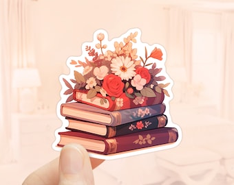May include: A stack of three vintage books with a bouquet of red, white and pink flowers on top. The books have floral patterns on their covers.