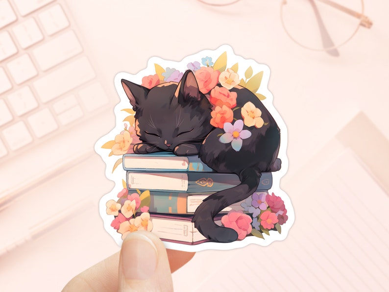 Pu&ograve; includere: Un gatto nero con gli occhi chiusi dorme su una pila di libri colorati. Il gatto &egrave; circondato da fiori rosa, arancioni, gialli e viola.