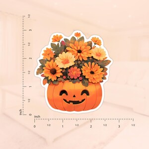 K&ouml;nnte beinhalten: Ein l&auml;chelnder K&uuml;rbis mit einem Strau&szlig; orangefarbener, gelber und roter Blumen im Inneren. Der K&uuml;rbis ist orange und die Blumen sind symmetrisch angeordnet.