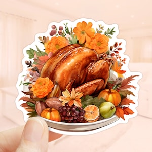 May include: A sticker depicting a watercolour illustration of a roasted turkey surrounded by orange flowers, pumpkins, grapes, and other autumn harvest elements. The turkey is golden brown, evoking a Thanksgiving theme.