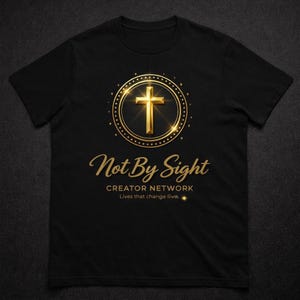 May include: Black t-shirt featuring a gold cross design within a circle, with the words "Not By Sight" and "Creator Network" in gold script. The shirt also includes the text "Lives that change lives."
