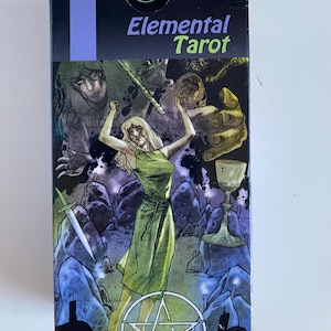 May include: A tarot card deck box with the words "Elemental Tarot" in green and purple. The box features a fantasy illustration of a woman in a green dress, a sword, a chalice, and other figures in a dark, mystical setting.