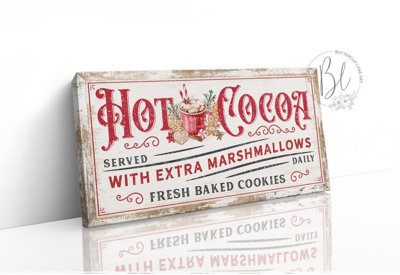 May include: A white wooden sign with red lettering that reads "Hot Cocoa Served With Extra Marshmallows Fresh Baked Cookies Daily". The sign has a vintage look and features a red and white illustration of a mug of hot cocoa with marshmallows.