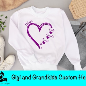 Peut inclure: Sweat-shirt blanc avec un motif de cœur violet qui dit "Gigi" en haut et "Caleb", "Maddie" et "Hunter" à l'intérieur du cœur. Le texte "Licence commerciale incluse" est dans un cercle bleu.