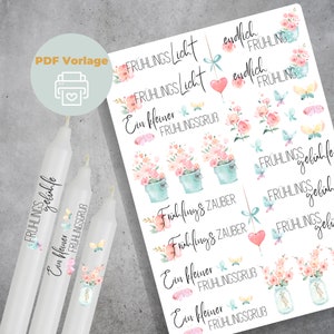 Puede incluir: Un conjunto de pegatinas imprimibles con diseños de temática primaveral. Las pegatinas incluyen flores, mariposas y texto en alemán que dice "Frühlingszauber" y "Ein kleiner Frühlingsgruß".