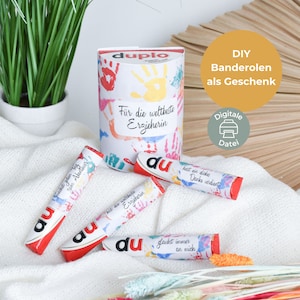 Puede incluir: Un conjunto de cuatro etiquetas de regalo imprimibles de colores con la palabra "du" y diseños de huellas de manos. Las etiquetas están diseñadas para un maestro o educador e incluyen frases como "Para el mejor maestro" y "Te mereces un gran agradecimiento".