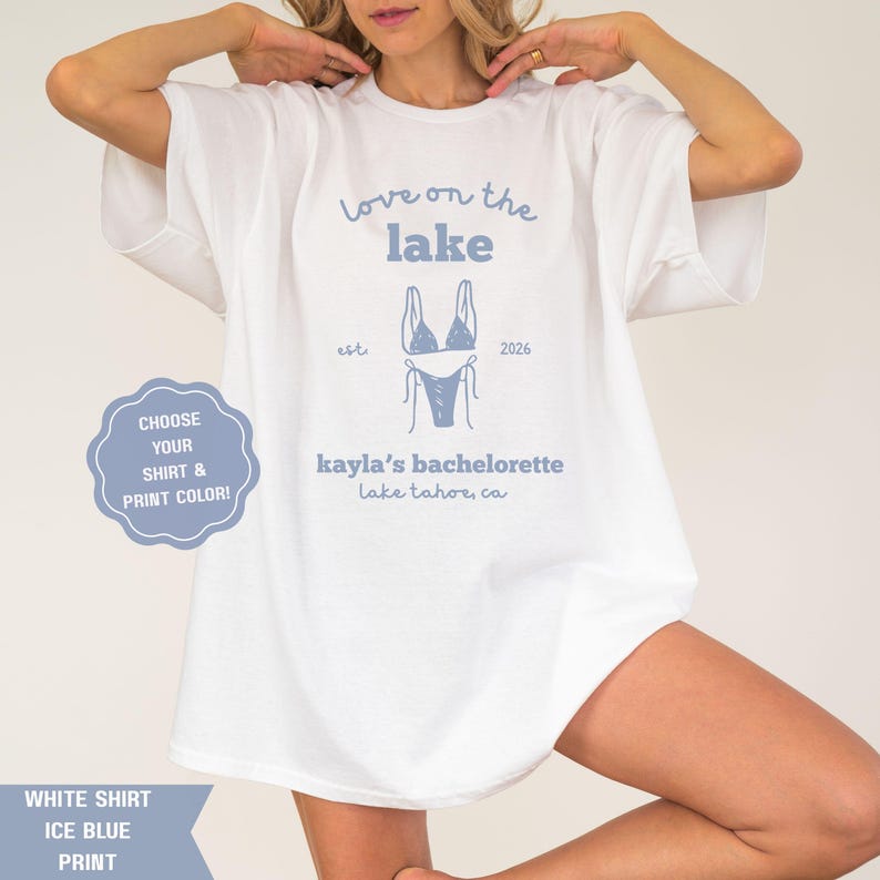 May include: White t-shirt with "Love on the Lake" and "kayla's bachelorette" text in ice blue. A bikini graphic is centered below the text. The shirt also has the text "Lake Tahoe, CA".