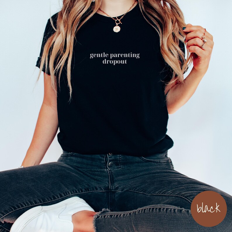 Op de afbeelding: Zwart T-shirt met de tekst "gentle parenting dropout" in witte letters.