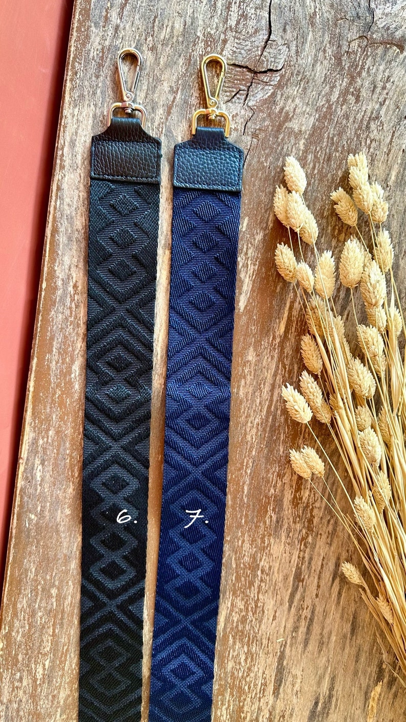 May include: Two fabric straps with gold clasps. The strap on the left is black with a geometric pattern. The strap on the right is navy blue with a geometric pattern. The straps are labeled "6." and "7."