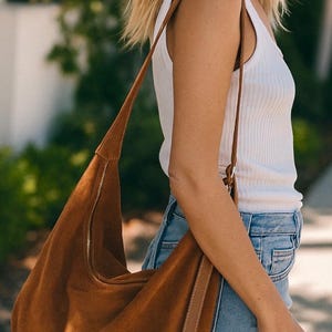 Bolsa transversal de camurça, tamanho XXL com alça de couro ajustável, detalhes dourados, ideal para presentear.