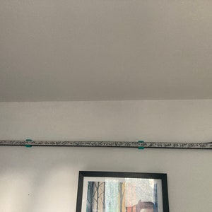 K&ouml;nnte beinhalten: Ein wei&szlig;er Hockeyschl&auml;ger mit schwarzem Klebeband auf der Klinge. Der Schl&auml;ger ist mit schwarzem Stift von mehreren Personen signiert. Der Schl&auml;ger ist an einer wei&szlig;en Wand montiert.