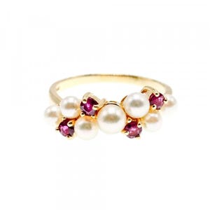 May include: A gold ring featuring a cluster of white pearls and small, round, deep red gemstones. The ring has a delicate, elegant design, perfect for special occasions.