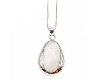 May include: A silver-toned pendant necklace featuring a pear-shaped, white, iridescent stone. The stone is encased in a polished silver setting and hangs from a delicate silver chain. The pendant has a smooth, reflective surface.