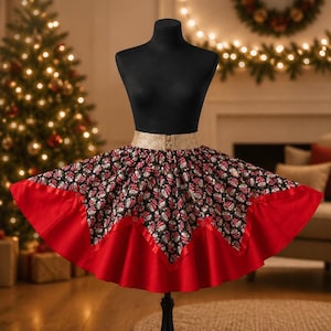 May include: A black mannequin torso displays a skirt featuring a black fabric base with a repeating pattern of Santa Claus faces. The skirt has a wide gold waistband and a solid red hem with a pointed, zig-zag edge and small red bows.