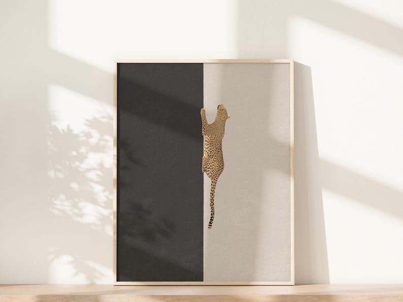 Hand drawn art print of a cheetah climbing vertically in the center of the print. The left side of the print is sold dark grey and the right side is a light tan/beige color.
