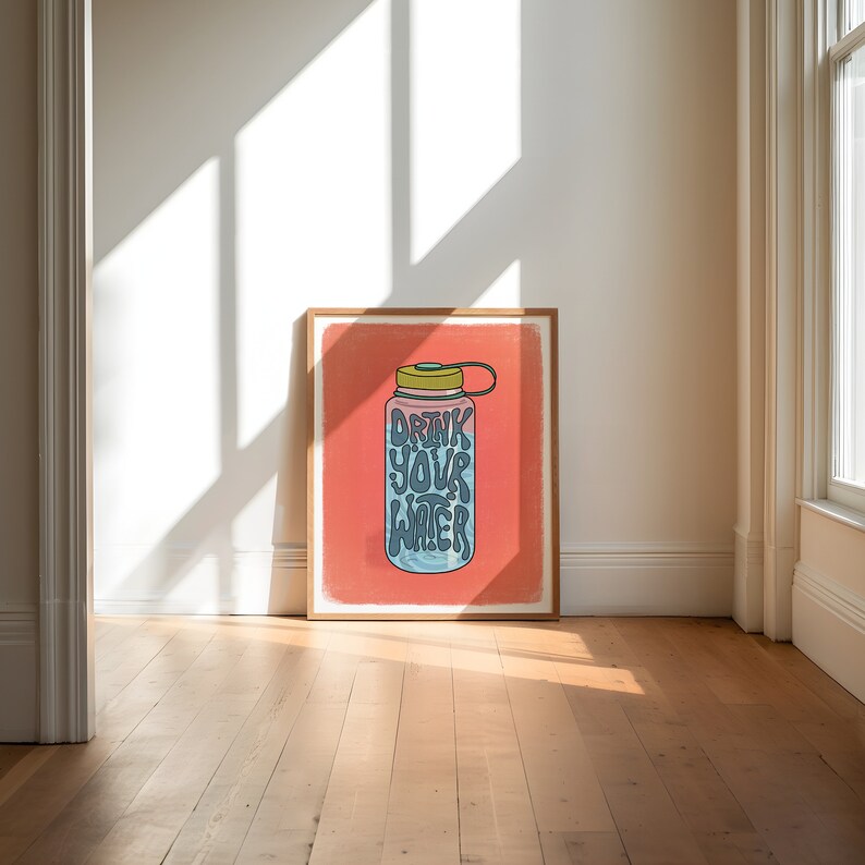 Art print of a water bottle that has the works "drink your water" on it in blue. The water bottle lid is green and the background is salmon pink.