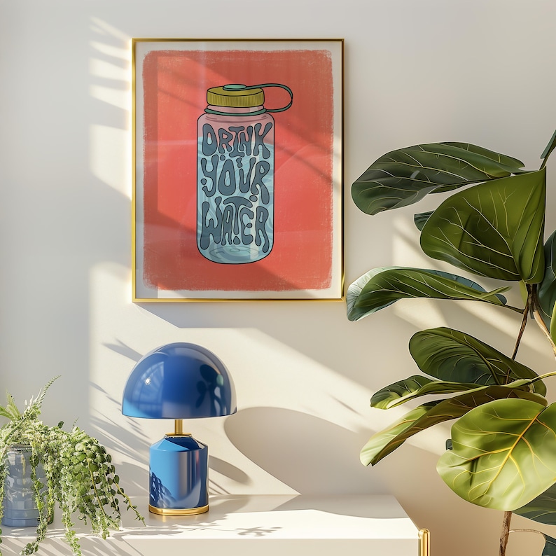 Art print of a water bottle that has the works "drink your water" on it in blue. The water bottle lid is green and the background is salmon pink.