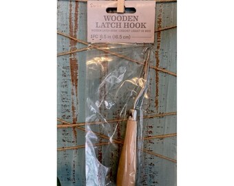 May include: A wooden latch hook with a metal hook and a light brown wooden handle. The hook is packaged in a clear plastic bag. The packaging reads "WOODEN LATCH HOOK" and "1PC 6.5 in (16.5 cm)".