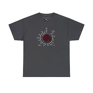 May include: Dark gray t-shirt featuring a graphic of a red and silver audio control knob. The knob has white markings for dB, LINE, OFF, and MIC. The shirt is a crew neck style.