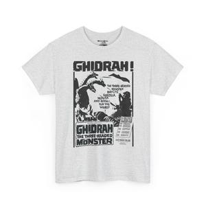 May include: A grey t-shirt with a black and white graphic print of a movie poster for the film "Ghidrah! The Three-Headed Monster". The poster features a three-headed dragon and the text "Ghidrah! The Three-Headed Monster".