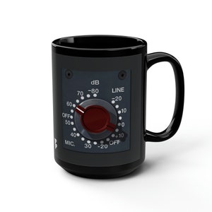 May include: Black ceramic mug with a graphic of a vintage audio mixer knob. The knob has a red center and a black dial with white markings. The dial reads "dB", "LINE", "MIC", "OFF", and numbers from 0 to 80.