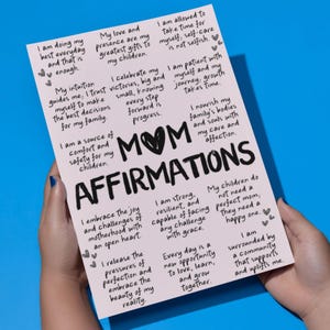 May include: Pink printable poster with the text "MOM AFFIRMATIONS" in black. The poster features a list of positive affirmations for mothers, including "I am doing my best everyday", "I am a source of comfort and safety for my children", and "I embrace the joy and challenges of motherhood".