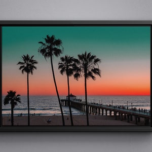 May include: A framed photograph of a beach scene with palm trees silhouetted against a vibrant sunset sky. The ocean is calm and the pier extends into the water.