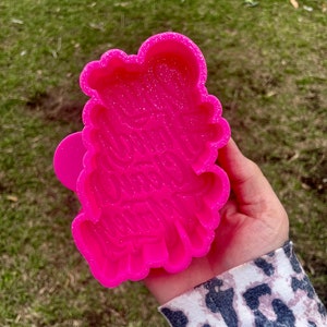 May include: Pink silicone mold with a glittery finish. The mold is shaped like a cloud and has the text "You were created to be beautiful" inscribed in it.