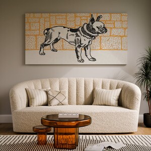 May include: A white, fluffy sofa with a black and white illustration of a dog on the wall above it. The sofa has three pillows, one with a striped pattern, one with a geometric pattern, and one with a solid color. There is a small table in front of the sofa with a glass top and a brown base.