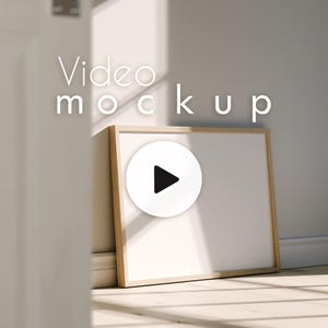 May include: A white video mockup frame with a wooden border, leaning against a wall. A white circle with a black play button is centered on the frame. The words "Video mockup" are above the frame.