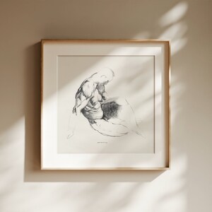Pu&ograve; includere: Un bozzetto a matita incorniciato di una figura seduta. L'opera d'arte &egrave; in bianco e nero, con ombreggiature e linee dettagliate. La cornice &egrave; di colore legno chiaro e l'opera &egrave; esposta su una parete dai toni neutri.