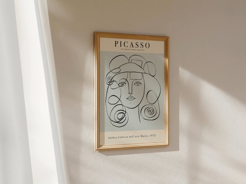May include: A framed print of a black and white line drawing of a woman's face. The print is titled "PICASSO" and has the text "Anthera Galleria dell'arte Moderna, 1972" at the bottom.