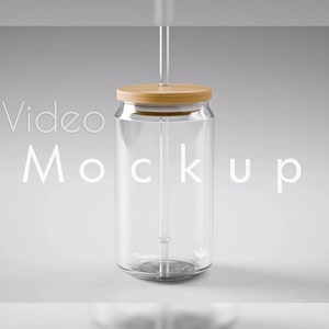 May include: A clear glass can with a wooden lid and a straw. The can is labelled "Video Mockup".