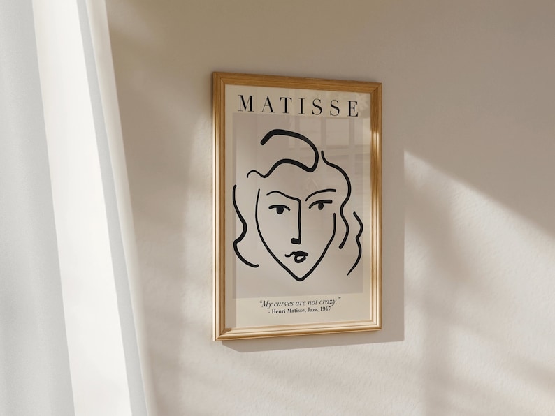May include: A framed black and white line drawing of a woman's face with the text "MATISSE" at the top and the quote "My curves are not crazy." - Henri Matisse, June, 1947 at the bottom.