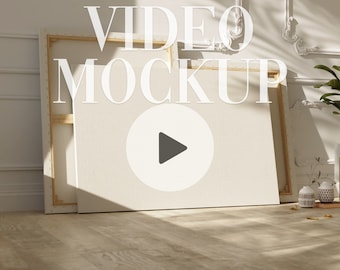 May include: A white canvas with a wooden frame, leaning against a white wall. A play button icon is visible on the canvas. The text "VIDEO MOCKUP" is superimposed on the image.