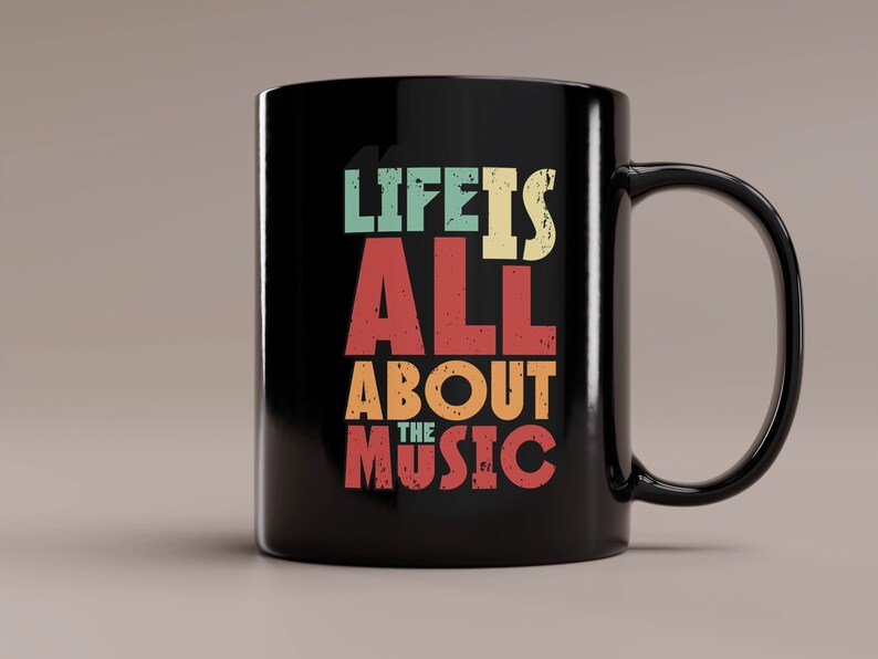 May include: Black ceramic coffee mug with a white design that reads "Life is all about the music" in a vintage style font with colorful accents.